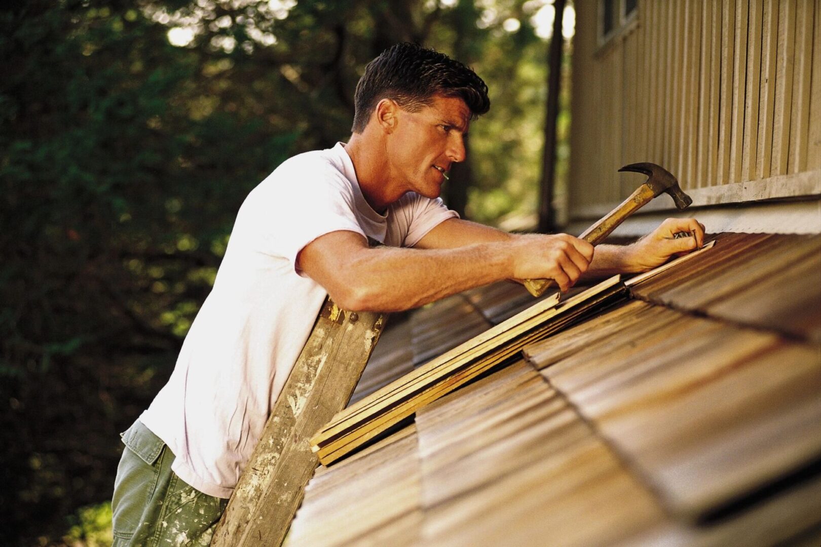 A man working on the roof of his house.